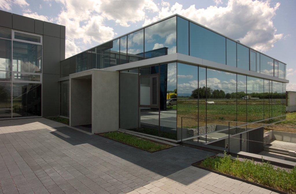 Ostansicht – verspiegeltes Sonnenschutzglas lässt das Gebäude mit der Umgebung verschmelzen