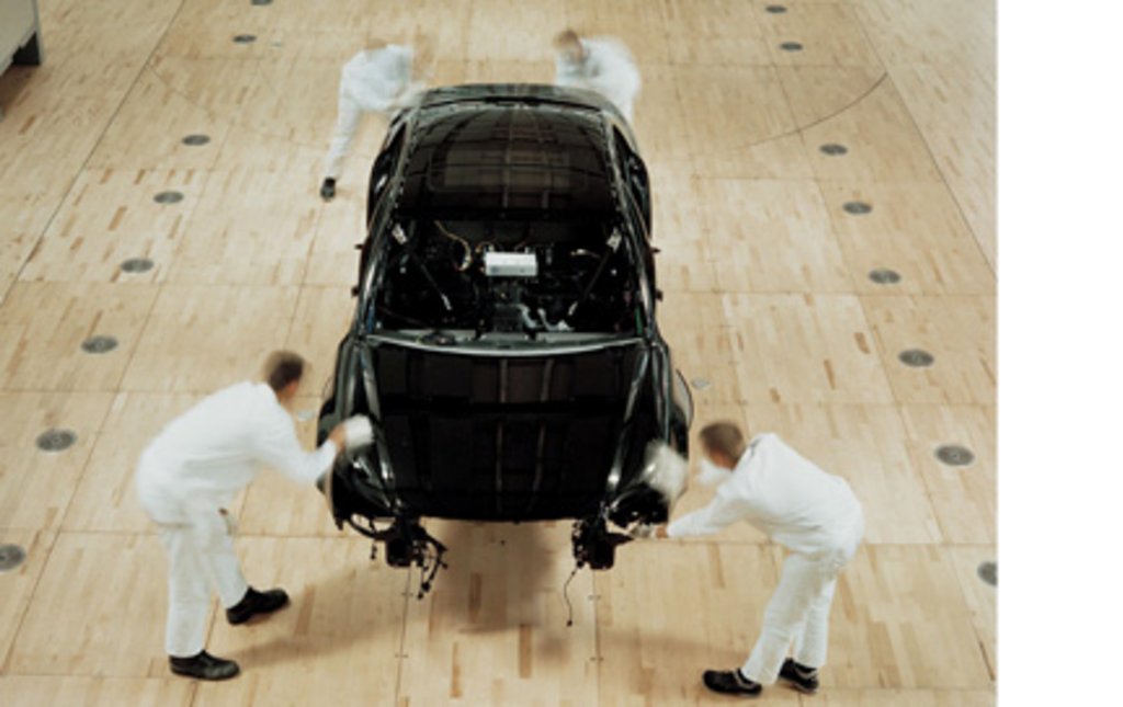 Die Entstehung des vornehmlich in Handarbeit gefertigten Automobils in hellen atelierartigen Räumen