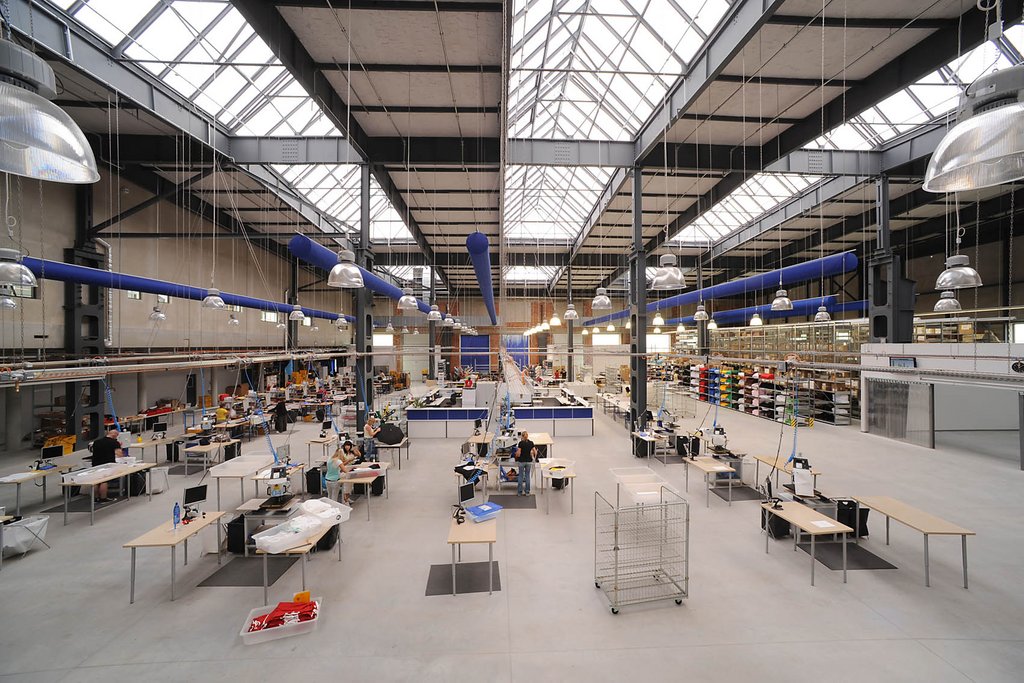 Die helle, großzügige Produktionshalle kombiniert industriellen Charme mit moderner Arbeitsplatzgestaltung