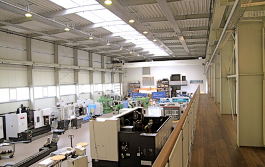 Neben Verkaufsflächen für neue Werkzeugmaschinen bietet die Halle auch Werkstatt- und Lagerbereiche für Aufarbeitung und Reparatur
